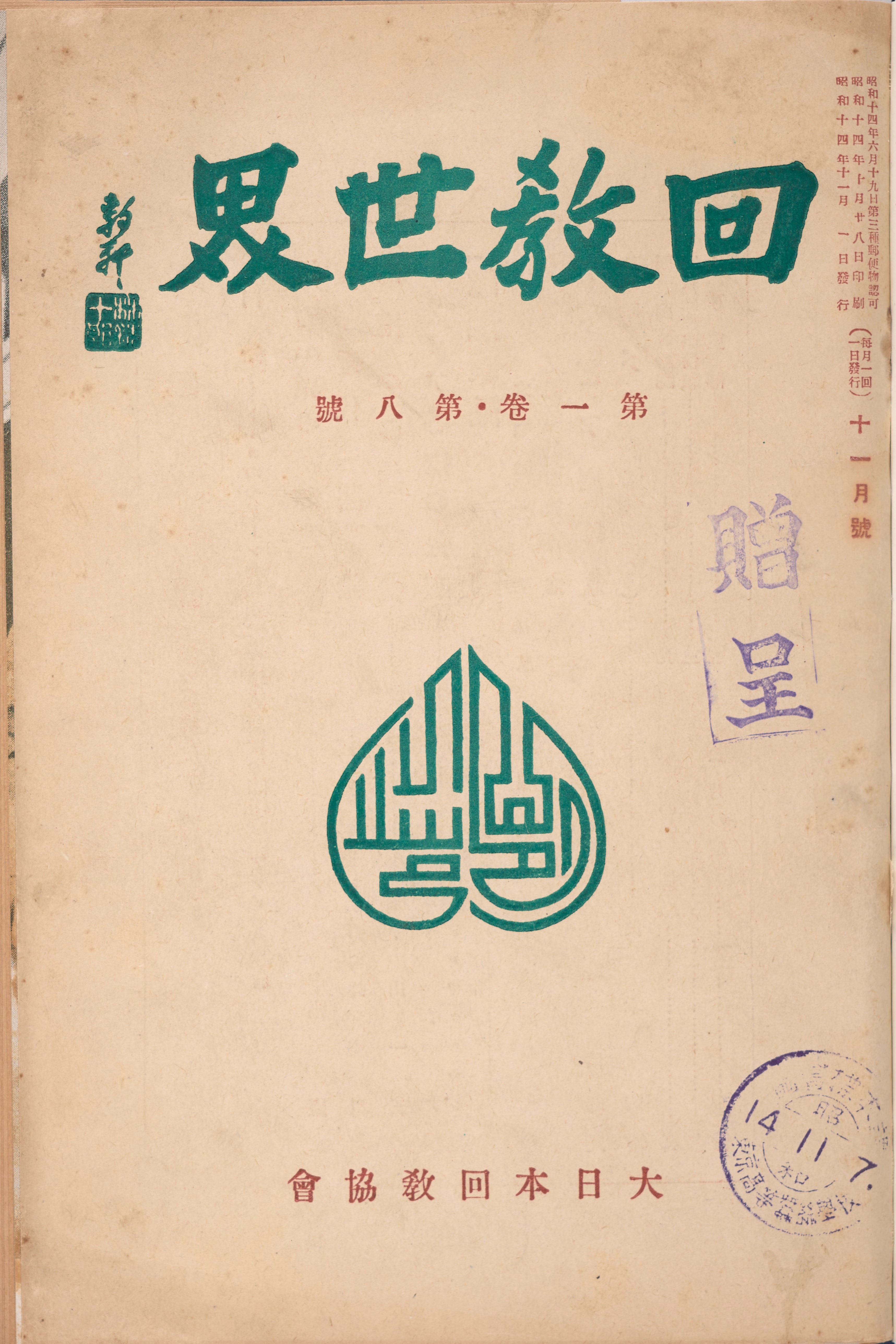 A worn, beige-colored book cover shows bold green Japanese text indicating a title over a prominent green emblem with intricate designs inside. Smaller red text as well as two faded purple stamps also adorn the page.